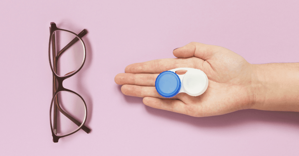 person debates between new glasses or contacts by looking at both over pink background