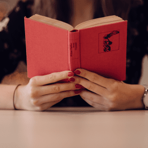 woman reads book for short period of time because her dry eyes are hurting her