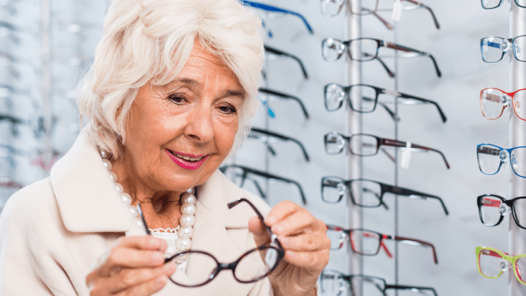 Woman trying on styles of Eye glasses from glasses wall at the Eye center