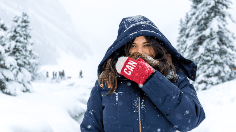 Woman standing outside in the snow squinting her eyes