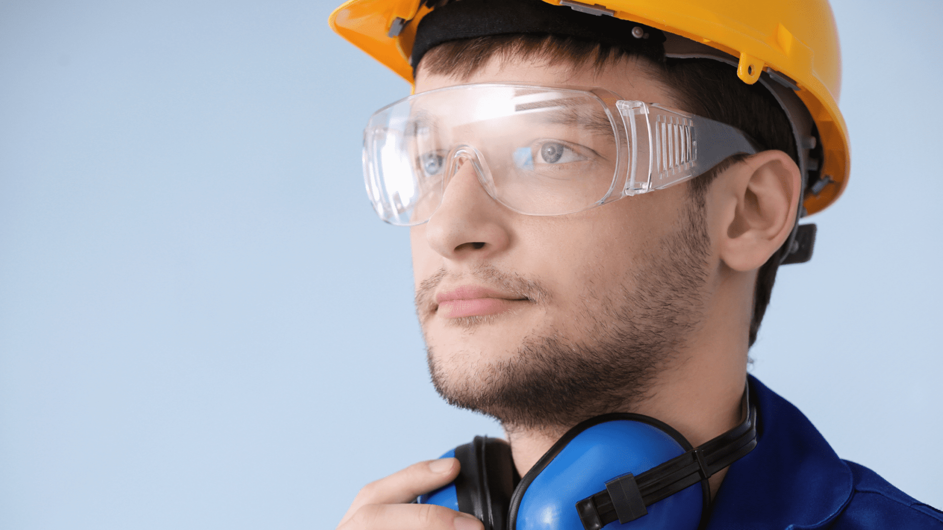 male worker wearing safety gear including protective helmet, ear protection and safety glasses